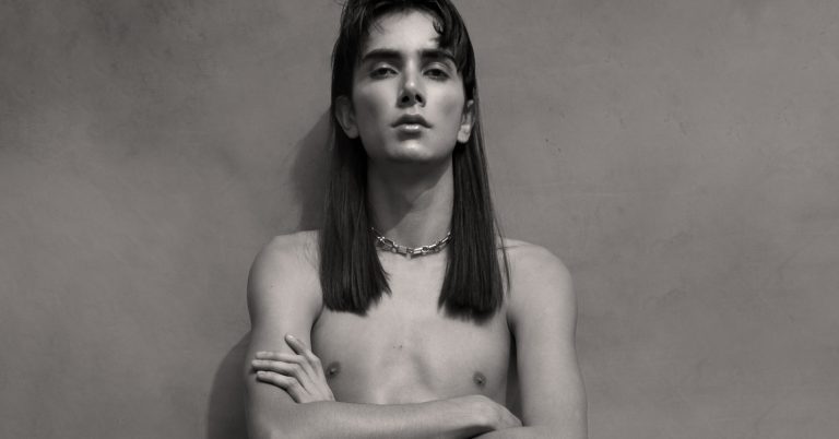 Shirtless non binary model model with arms crossed, long hair Heyboy Exclusive