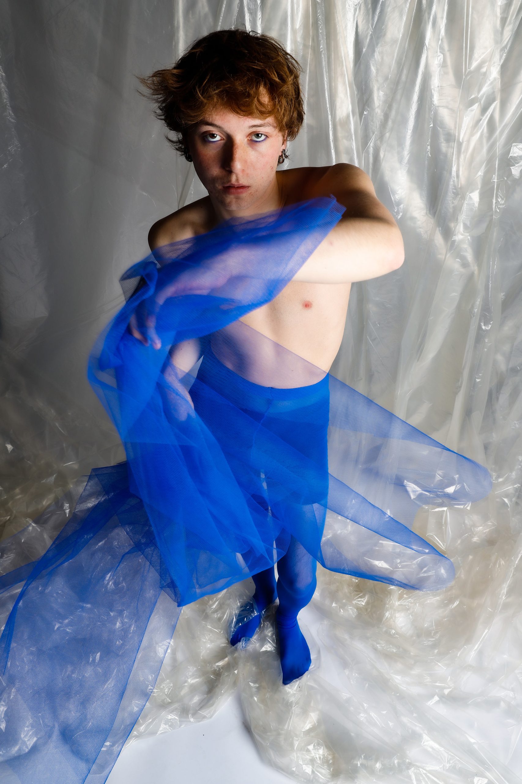 BLUEBOY — color studio portraits of a male figure posed against plastic and fabric, using soft light, blue tones, and minimal styling. HeyBoy Fanzine
